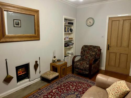 a living room with a couch and a chair and a fireplace at Underneath the Arches in Penicuik