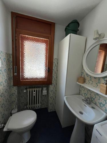 a bathroom with a toilet and a sink and a mirror at Casa vacanze la Primula in Sauze d'Oulx
