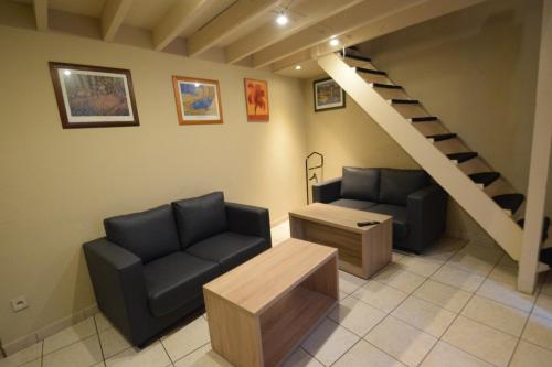 a living room with two chairs and a staircase at Condo Gardens Leuven in Leuven