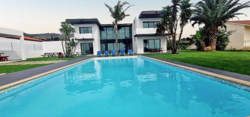 a large blue swimming pool in front of a building at Exceptional villa in Vila Franca Do Campo with private pool in Vila Franca do Campo