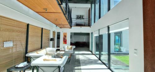 a living room with white furniture and glass walls at Exceptional villa in Vila Franca Do Campo with private pool in Vila Franca do Campo