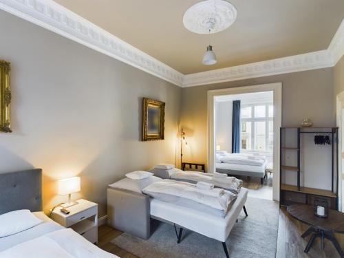 a bedroom with three beds and a room with two tables at Art Apartments in Hamburg