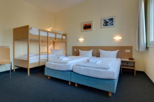 two beds in a room with two bunk beds at Familienhotel Citylight in Berlin