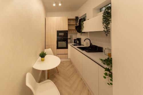 a small kitchen with a table and a small table and chairs at AIASTAY Bucharest River Apartments in Bucharest
