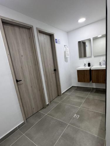 a bathroom with two wooden doors and a sink at Vida Hostel in Medellín