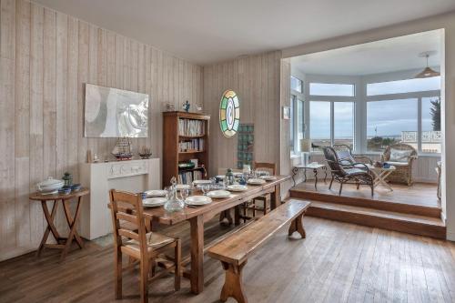 une salle à manger avec une table et des chaises et une cuisine dans l'établissement Maison pour 12 - Vue mer - Plage à La Bernerie, à La Bernerie-en-Retz