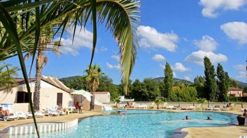 une grande piscine avec des gens dans un complexe hôtelier dans l'établissement Camping 4 étoiles - Parc aquatique - eece0c, à Grimaud