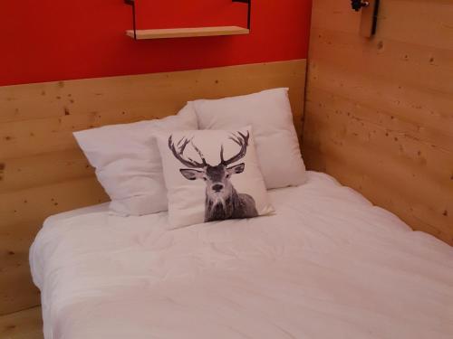 - une photo de cerf sur un lit avec des oreillers dans l'établissement Charmant appartement rénové 4 pers, balcon, pied des pistes, animaux admis - FR-1-516-154, à Les Deux Alpes