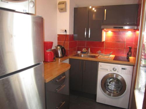 une cuisine avec un réfrigérateur et une machine à laver dans l'établissement Studio lumineux avec balcon, WiFi et parking à Brides-les-Bains - FR-1-512-242, à Brides-les-Bains
