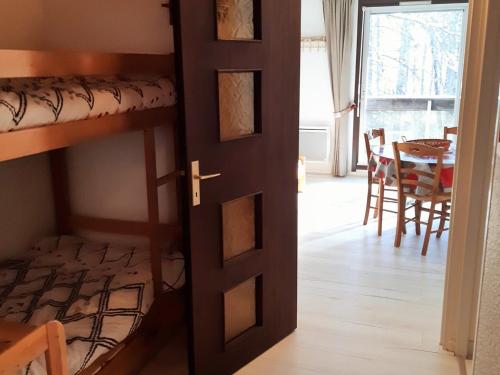 - une chambre avec des lits superposés et une salle à manger avec une table dans l'établissement Studio cosy 4 pers, balcon sud, pied des pistes, navette gratuite, animaux acceptés - FR-1-516-158, à Les Deux Alpes