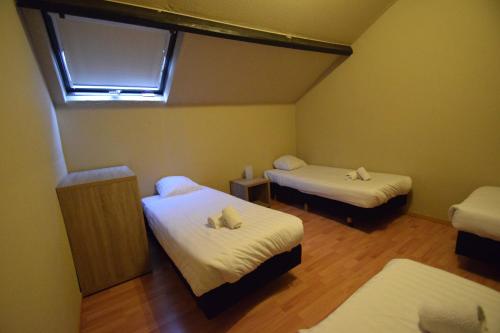 a small room with two beds and a window at Condo Gardens Leuven in Leuven