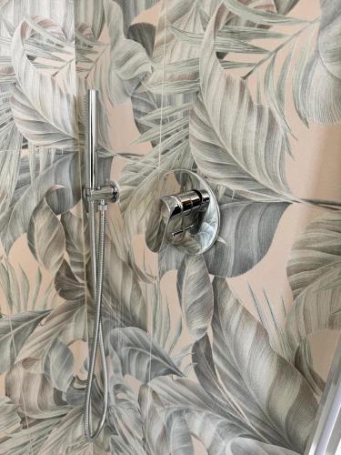 a shower in a bathroom with a mural of leaves at Hotel Corallo in Montecatini Terme