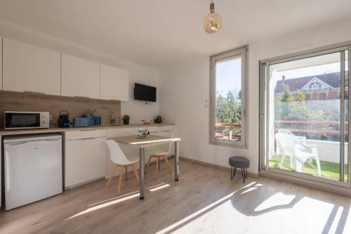 une cuisine avec une table et des chaises et une fenêtre dans l'établissement L'Océane - Joli studio avec balcon à Arcachon, à Arcachon
