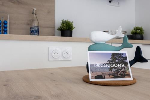 un livre posé sur une table à côté d'une figurine dans l'établissement L'Océane - Joli studio avec balcon à Arcachon, à Arcachon