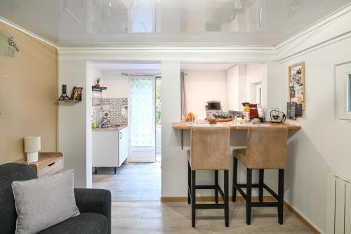 une cuisine et un salon avec un comptoir et des chaises dans l'établissement La P'tite Escapade - à 25 min de Caen, à Creully