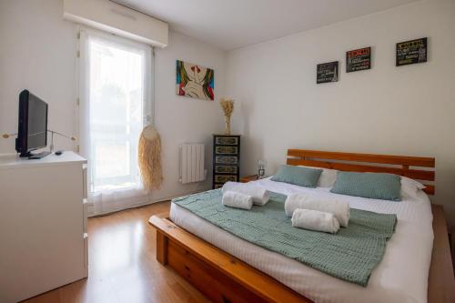 une chambre avec un grand lit avec deux oreillers dessus dans l'établissement Parenthèse de bonheur - 600 m de la plage, à Arcachon