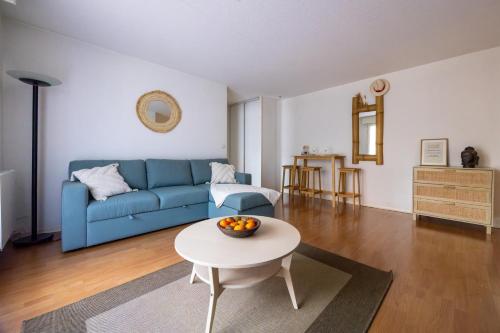 un salon avec un canapé bleu et une table dans l'établissement Parenthèse de bonheur - 600 m de la plage, à Arcachon