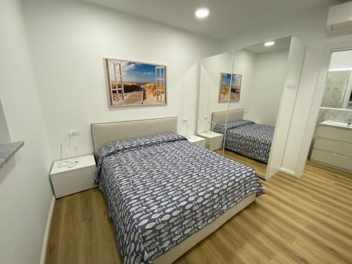 une chambre avec deux lits et un miroir dans l'établissement Little White House Loano, à Loano