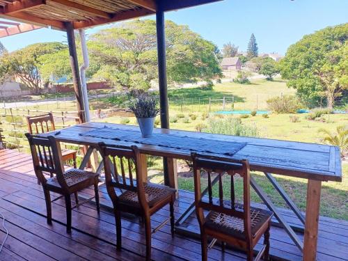 a wooden table with four chairs on a deck at The Jbaynian Guesthouse in Jeffreys Bay