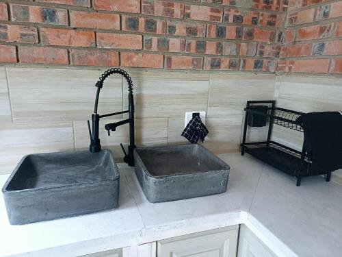 two concrete sinks on a counter in a kitchen at The Jbaynian Guesthouse in Jeffreys Bay