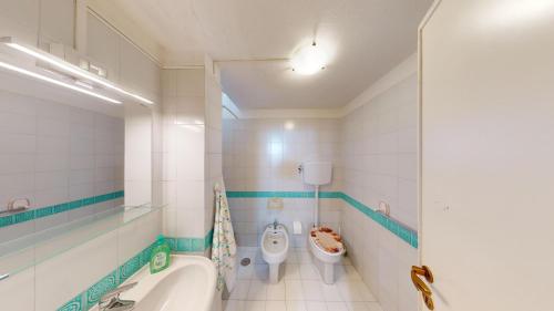 a bathroom with two toilets and a tub and a sink at Villa Marina in Campu Longu