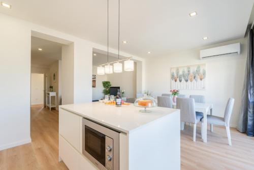a kitchen and living room with a white counter top at Bright & Spacious Retreat with Balcony by HostWise in Porto