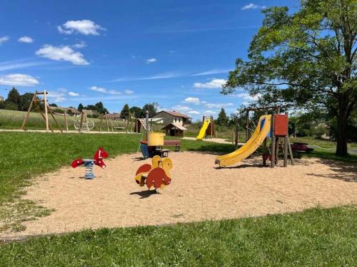 a park with a playground with toys in the sand at Chalet 3 étoiles - eeiid0 in Matour