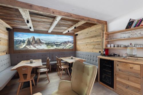 a restaurant with two tables and a large window at Chalet-Suite Panorama in Selva dei Molini