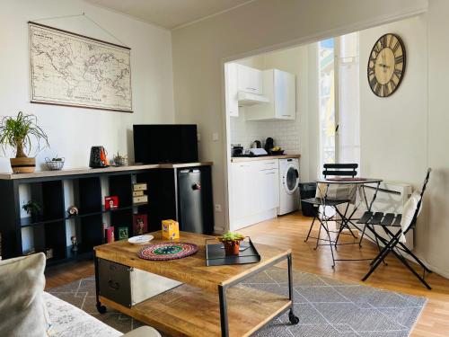un salon avec une table et une cuisine dans l'établissement Charmant studio en plein coeur de Nice, à Nice