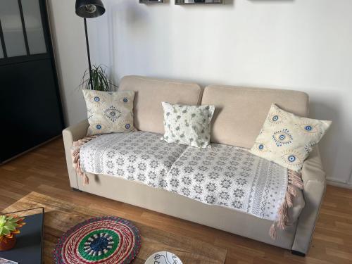 un canapé avec des coussins dessus dans un salon dans l'établissement Charmant studio en plein coeur de Nice, à Nice