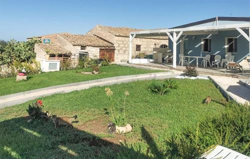 una casa con un patio con gatos sentados en el césped en Lovely Home In Ragusa With Wifi, en Ragusa