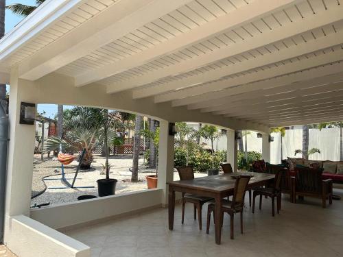 a patio with a wooden table and chairs on it at Paradera Palms Apt 1 in Paradera