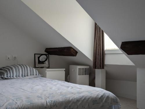 une chambre blanche avec un lit et une fenêtre dans l'établissement T2 Au pied du château sans vis à vis, à Saumur