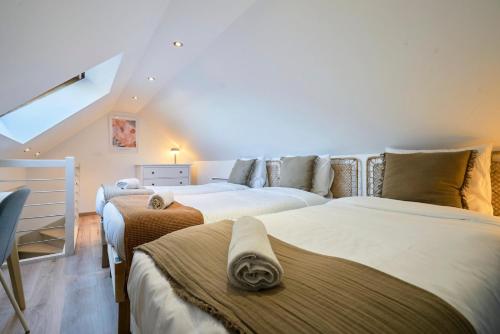 two beds in a room with a attic at Maison 2 chambres avec petite cour, proche métro in Lille