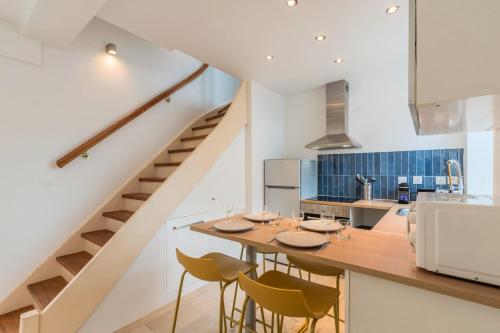 a kitchen with a table and chairs and a staircase at Maison 2 chambres avec petite cour, proche métro in Lille