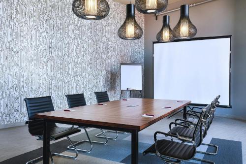 a conference room with a large wooden table and chairs at Aloft Guadalajara Sur in Guadalajara