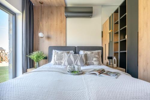 a bedroom with a large bed with a book at Wierchy View - LoftAffair Collection in Kościelisko