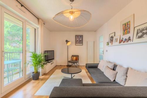 un salon avec un canapé et une table dans l'établissement Appartement une chambre avec parking & balcon, à La Madeleine