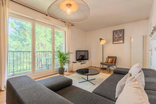 un salon avec un canapé et une télévision dans l'établissement Appartement une chambre avec parking & balcon, à La Madeleine