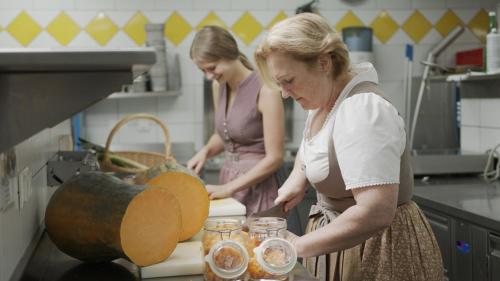 two women standing in a kitchen preparing food at Gastagwirt in Eugendorf
