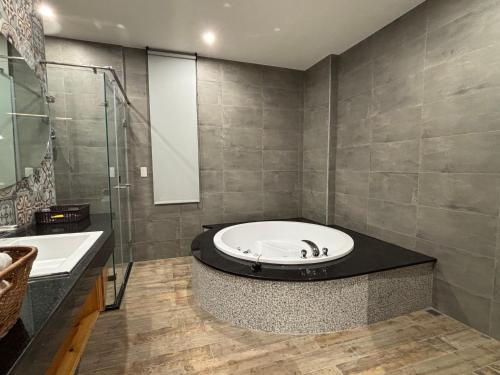 a bathroom with a tub and a glass shower at Romantic Code Art Motel in Shanhua