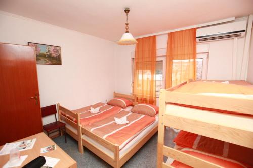 a bedroom with two bunk beds and a table at Hostel Cuba in Banja Luka