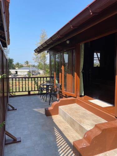 a patio with a table and chairs and a fence at Niyang Siam House in Nai Yang Beach