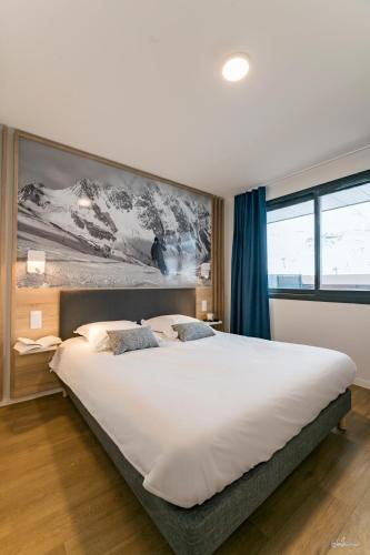 - une chambre avec un grand lit blanc orné d'une peinture murale dans l'établissement Lagrange Vacances Le Cristal de Piau, à Aragnouet