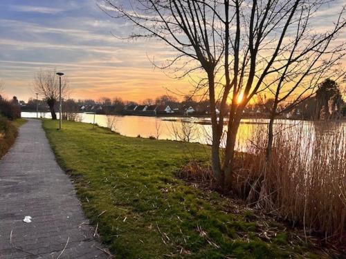 a path next to a body of water with the sunset at Sunparks 274 in Koksijde