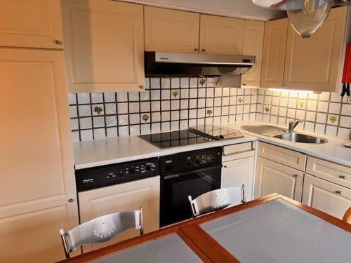 a kitchen with white cabinets and a black stove top oven at Sunparks 274 in Koksijde