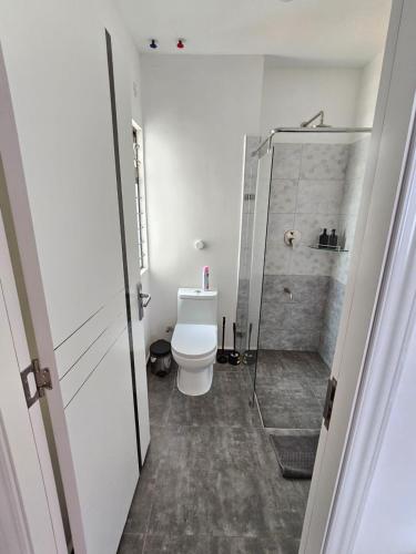 a bathroom with a toilet and a glass shower at orana homes II in Ruiru