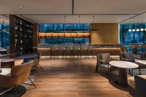 a restaurant with tables and chairs and a bar at Courtyard by Marriott Foshan Gaoming in Foshan