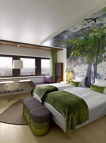 a bedroom with two beds and a mural of trees at Scandic Copenhagen in Copenhagen