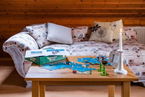 a table with a couch and a table with a wine glass at Landhaus Wern's Mühle in Ottweiler